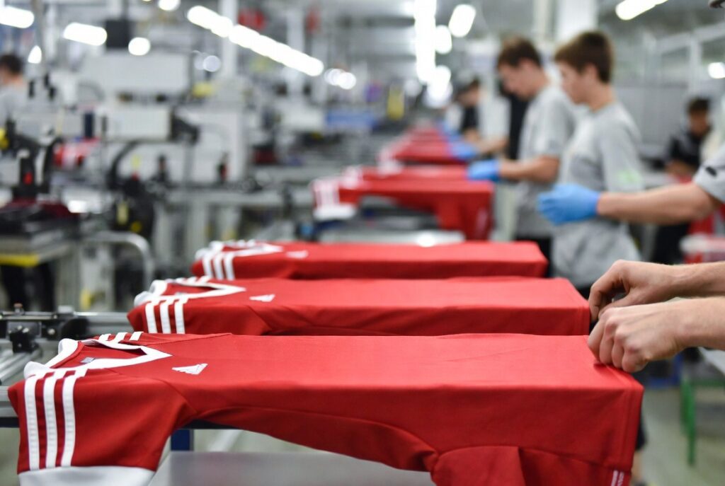 workers are making the uniform t shirt in machines  in factory 
